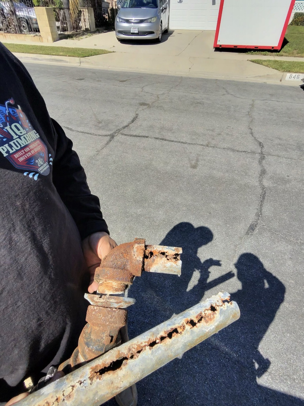 Technician holding a corroded pipe removed from a customer's home